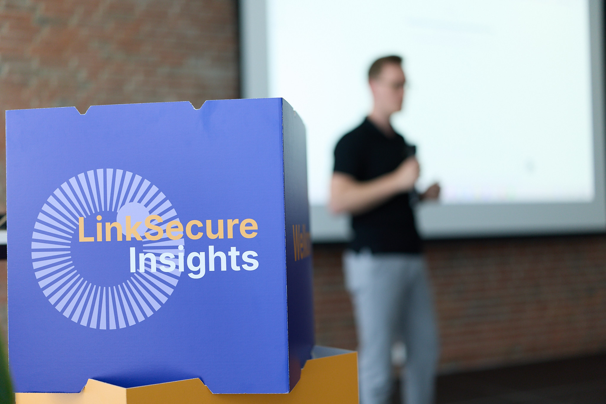 LinkSecure Insights logo op een kobus met spreker David van Lent op de achtergrond